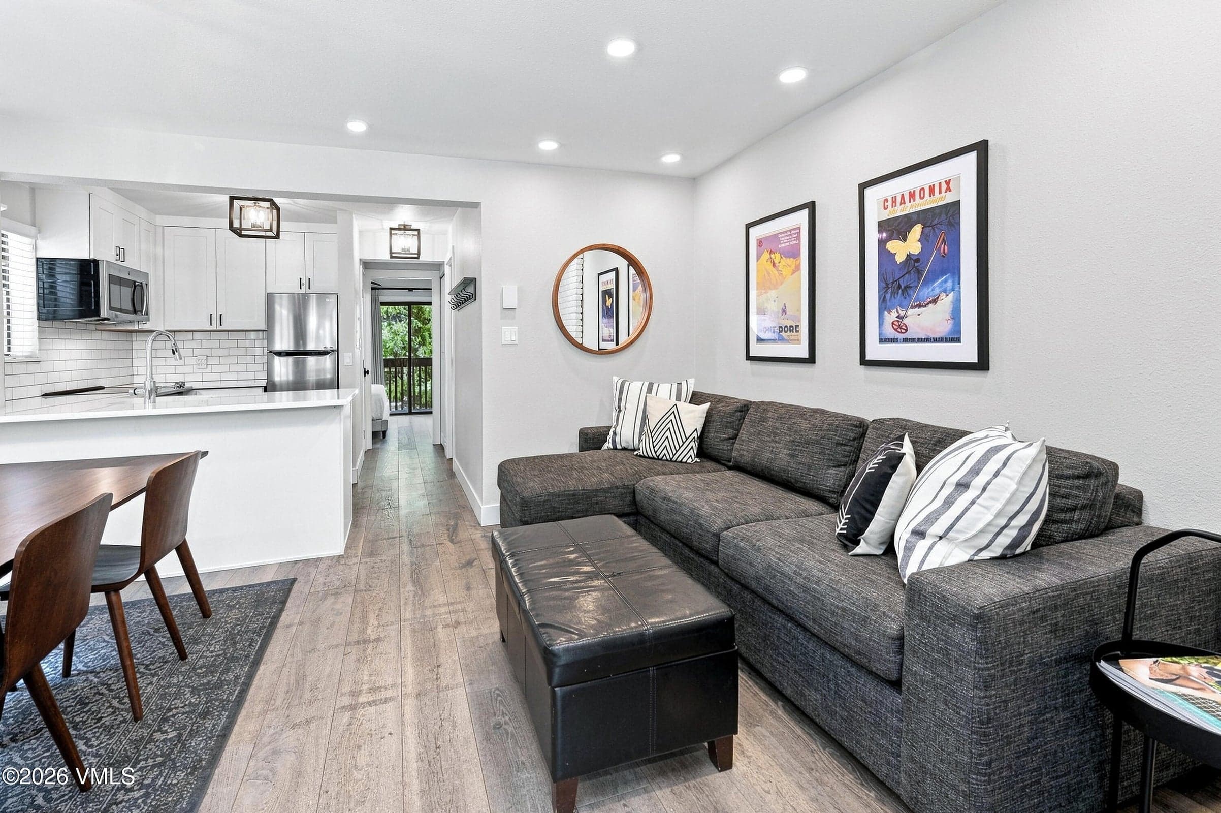 Living room with sectional sofa, gas fireplace, and framed ski posters.