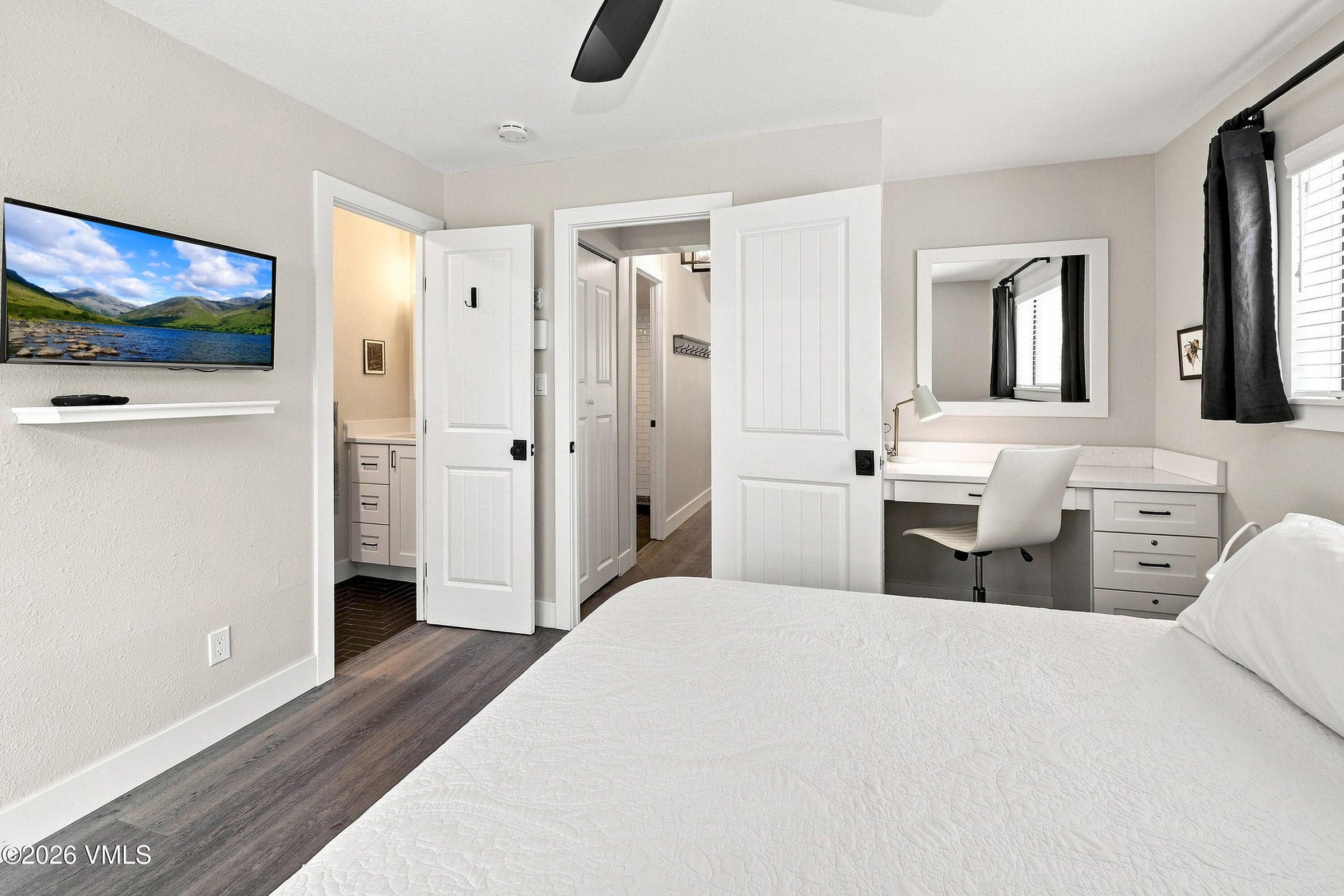 Primary bedroom with access to ensuite bath, closet, and desk area.