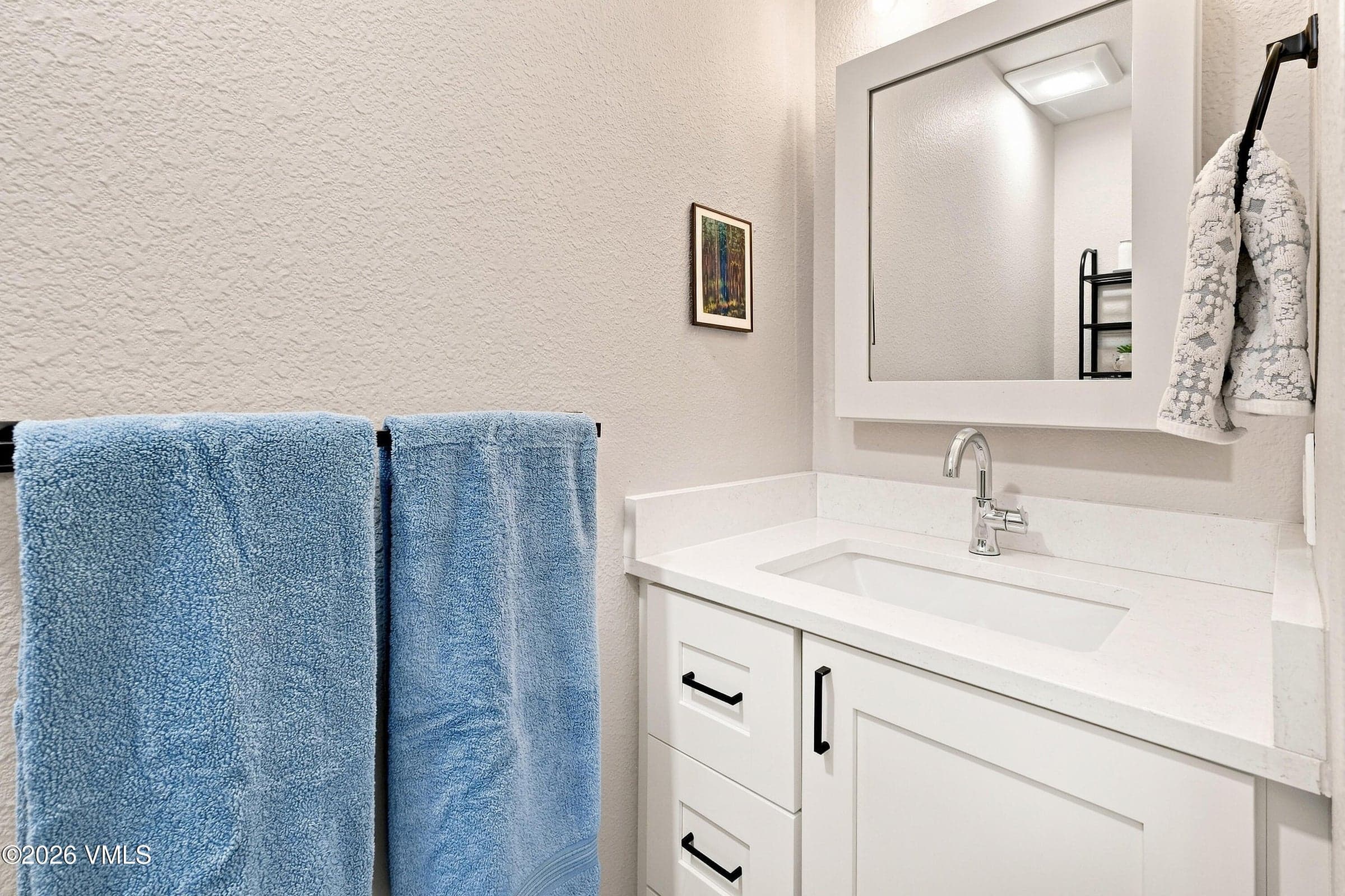 Primary ensuite powder bath vanity with quartz counter.