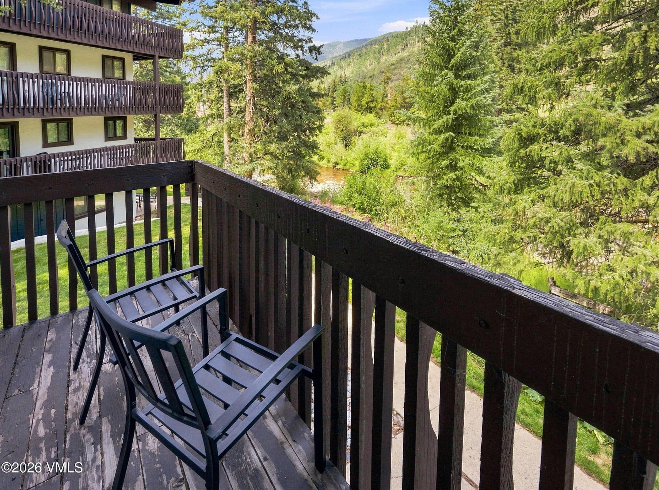 Private balcony seating overlooking Gore Creek and the forest.