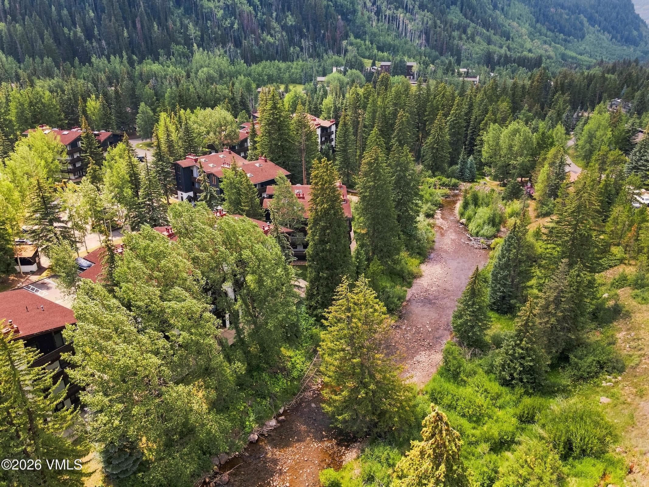 Aerial view of the Vail Racquet Club community lining Gore Creek, surrounded by national forest.