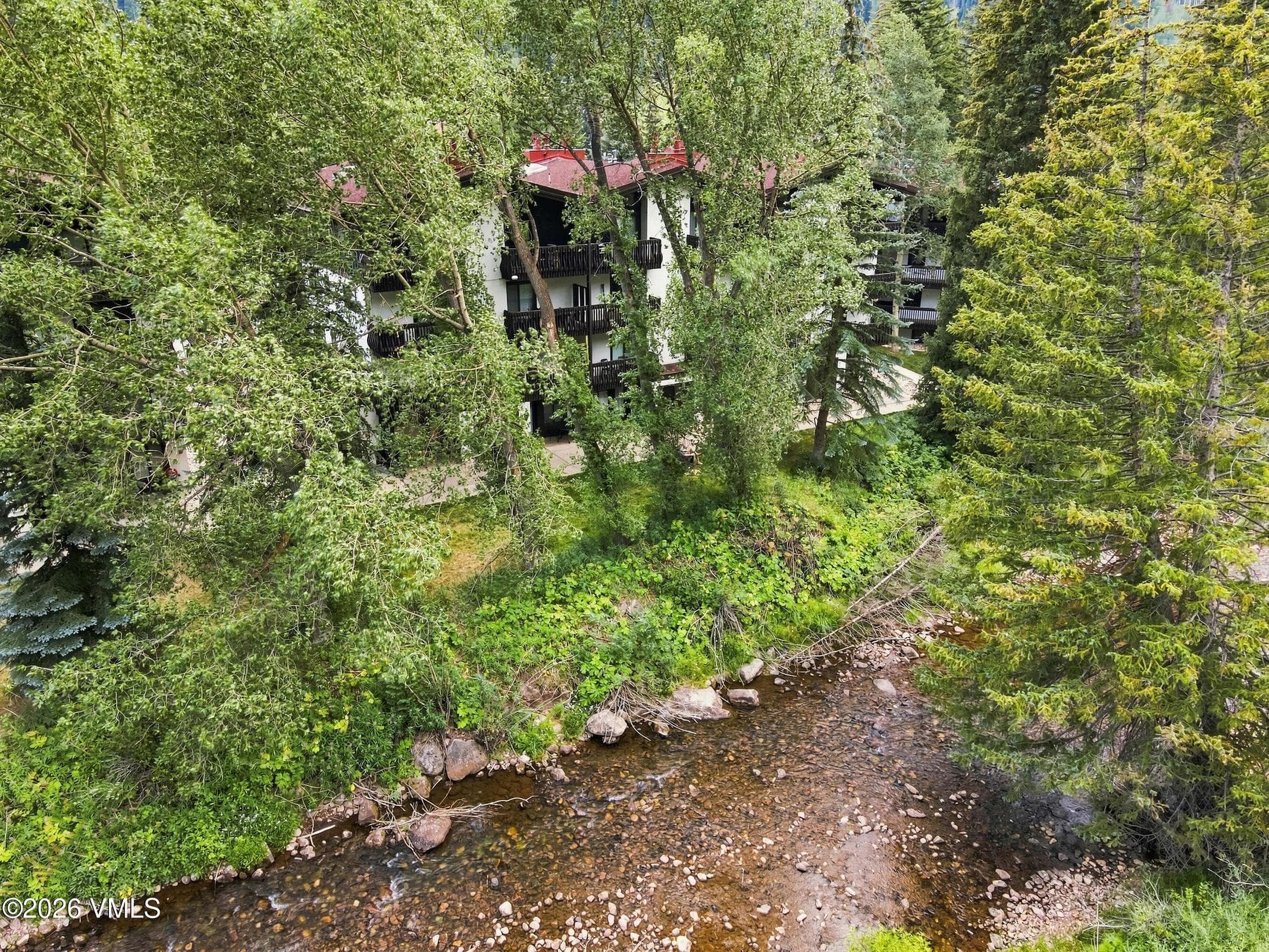 Aerial view of the building through aspens along Gore Creek.