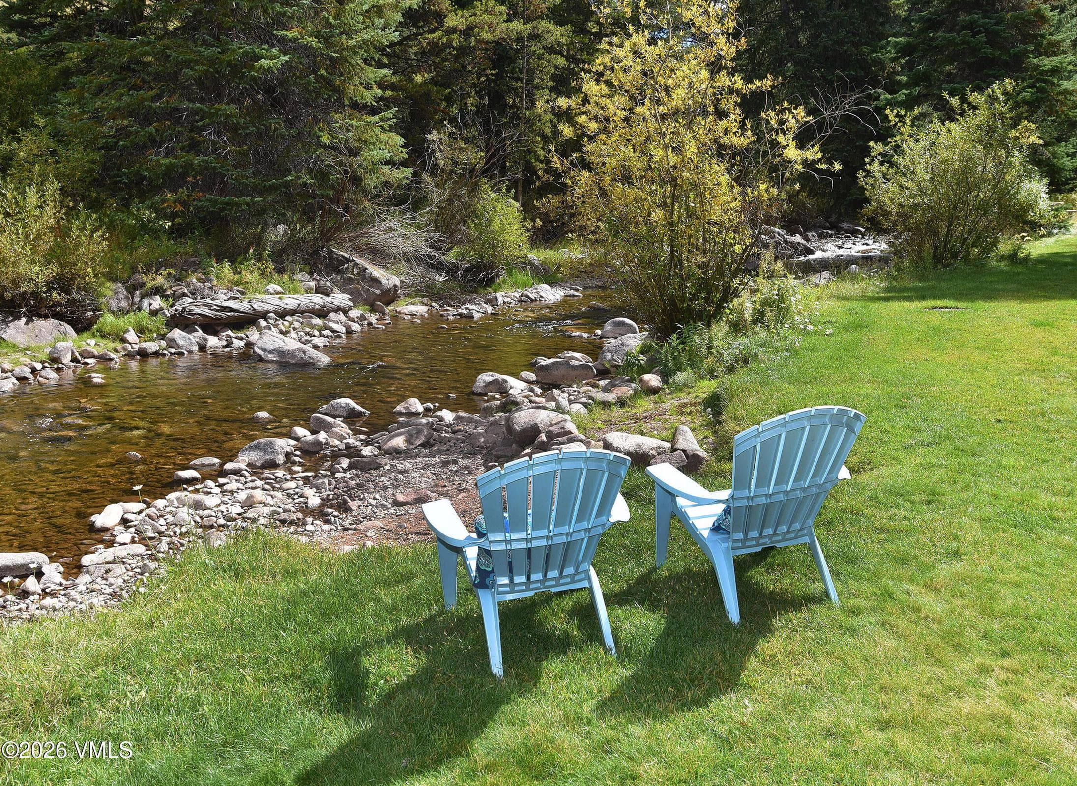Creekside seating close-up with fall color along the water.